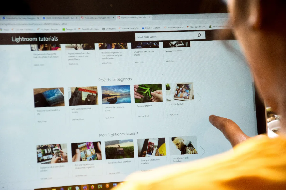 A person browsing a page densely packed with thumbnail tiles on a large screen